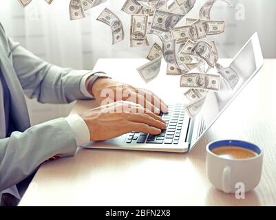 Finanzkonzept. Verdienen Sie Geld im Internet. Mann, der im Büro mit einem Laptop arbeitet Stockfoto