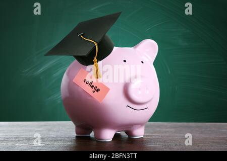 Sparschwein mit schwarzem Graduate Hut auf Tafel Hintergrund. Geld für College-Konzept Stockfoto