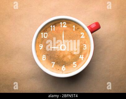 Tasse Kaffee auf beigem Hintergrund, Draufsicht. Zeitkonzept Stockfoto