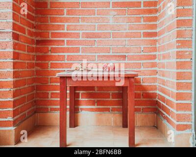 mall braunen Tisch an einer roten Backsteinwand kleben Stockfoto