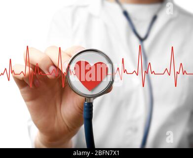 Elektrokardiogramm, rotes Herz und weibliche Hand mit Stethoskop, Nahaufnahme. Kardiologiekonzept. Stockfoto