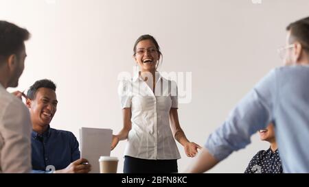 Diverse Seminarteilnehmer und Coach lachen während der Firmenschulung Stockfoto
