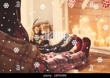 Paar entspannen vor dem Kamin zu Hause, Nahaufnahme. Verschneite Optik. Konzept für Weihnachtsfeiern. Stockfoto