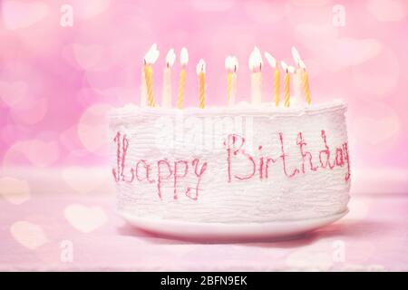 Geburtstagskuchen mit Kerzen auf rosa Hintergrund Stockfoto
