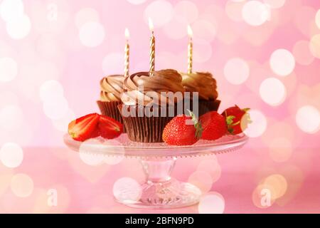 Leckere Schokolade Cupcakes mit Erdbeere auf rosa Hintergrund Stockfoto