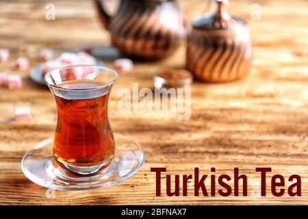Türkischer Tee in traditionellem Glas auf Holztisch, Nahaufnahme Stockfoto