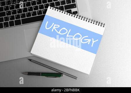 Word UROLOGY geschrieben in Notebook und Laptop auf dem Tisch. Konzept der Gesundheitsfürsorge Stockfoto