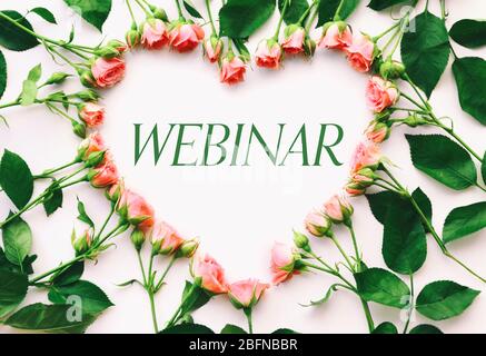 Herzförmiger Rahmen von Blumen. Word-WEBINAR auf weißem Hintergrund. Floristin und Blumendesign Tutorial Konzept. Stockfoto