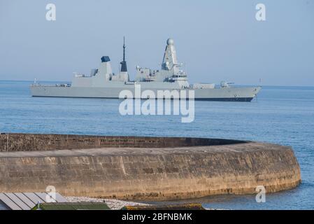 Lyme Regis, Dorset, Großbritannien. April 2020. UK Wetter: Royal Navy Typ 45 Destroyer HMS Dauntless verankert in der Nähe der Cobb bei Lyme Regis während der Coronavirus Sperrung. Eine Ankündigung wurde gehört, die die Reederei daran erinnerte, an Deck 2 Meter voneinander entfernt zu bleiben. Kredit: Celia McMahon/Alamy Live News Stockfoto