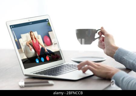 Frau beobachtet Sporttraining online auf dem Laptop. Fitness und Sport Blog. Stockfoto