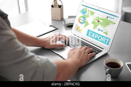 Logistikkonzept. Mann mit Laptop. Word-EXPORT und Weltkarte auf dem Bildschirm Stockfoto