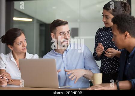 Multiethnische Kollegen arbeiten zusammen und hören Teamleiter zu Stockfoto