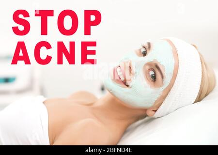 Junge Frau mit Gesichtsmaske bei Dermatologen. Text STOPPEN AKNE auf Hintergrund Stockfoto