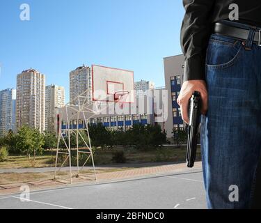 Mann mit Gewehr auf Schulspielplatz Stockfoto