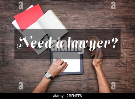 Mann mit einem modernen Laptop. TEXT BRAUCHEN SIE EINEN ANWALT? Im Hintergrund Stockfoto