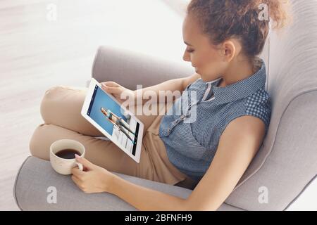 Frau beobachtet Sporttraining online auf Tablet. Fitness und Sport Blog. Stockfoto