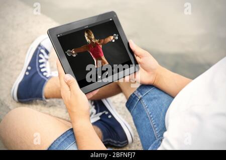 Mann beobachtet Sporttraining online auf Tablet. Fitness und Sport Blog. Stockfoto