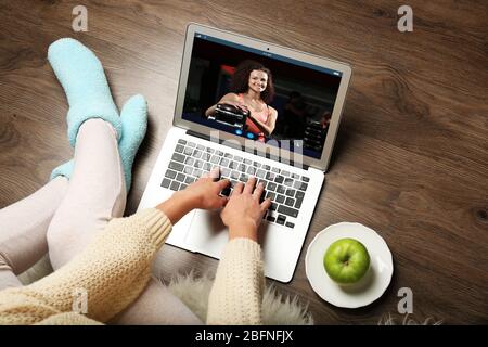 Frau beobachtet Sporttraining online auf dem Laptop. Fitness und Sport Blog. Stockfoto