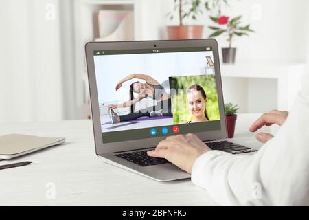 Frau beobachtet Sporttraining online auf dem Laptop. Fitness und Sport Blog. Stockfoto