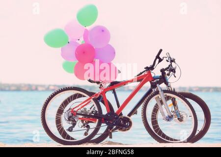 Bunte Ballons und Fahrräder am Flussufer Stockfoto