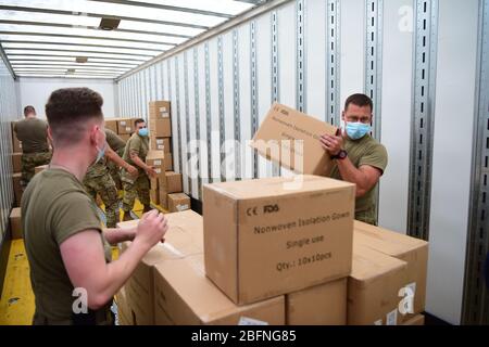 Arkansas National Guardsmen entlud sechs 18-Rad-Lastwagen voller persönlicher Schutzausrüstung für den Einsatz bei der Bekämpfung der COVID-19, Coronavirus-Pandemie 12. April 2020 in North Little Rock, Arkansas. Stockfoto