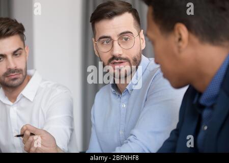 Verschiedene Mitarbeiter hören Teamleiter bei Briefing-Meeting Stockfoto