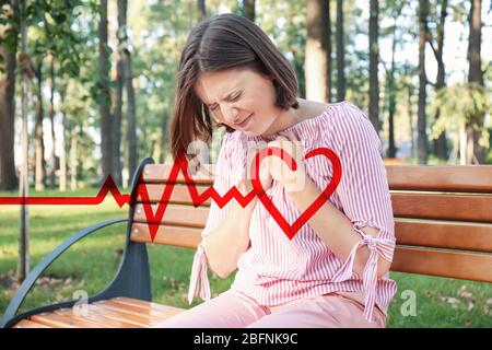 Frau, die an einem Herzinfarkt im Freien leidet Stockfoto