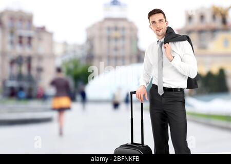 Junger Geschäftsmann mit Gepäck im Freien Stockfoto