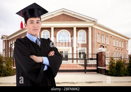 Student in Graduation Kleid und Mütze auf Campus-Gebiet Stockfoto