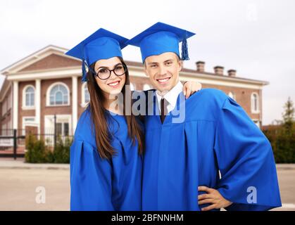 Studenten in Abschlusskleider und Kappen auf dem Campus Stockfoto