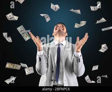 Erfolgreicher Börsenmakler mit fliegendem Geld auf Farbhintergrund Stockfoto