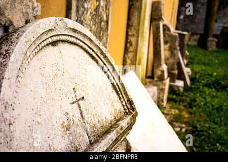 Verlassene Friedhof alten Zement Grabsteine, die von der Wand gefallen. Stockfoto