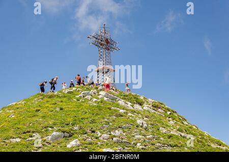 Blick auf Wanderer und das Kreuz auf dem Gipfel von Le Reculet auf Jura-Gebirge, Frankreich Stockfoto