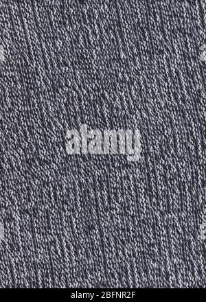 Struktur aus gestricktem Material. Hintergrund bei kaltem Wetter. Warmschwarze und weiße Wollpullover. Gestrickter Materialhintergrund. Stockfoto