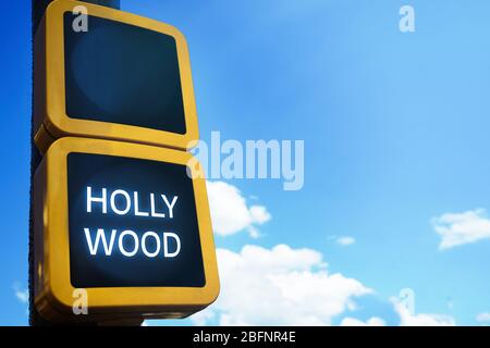Grüne Ampel mit Wort HOLLYWOOD auf Himmel Hintergrund Stockfoto