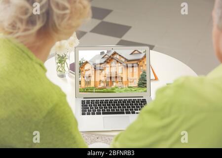 Online-Shopping-Konzept. Senior Paar auf der Suche nach Haus auf Immobilienmarkt Website Stockfoto