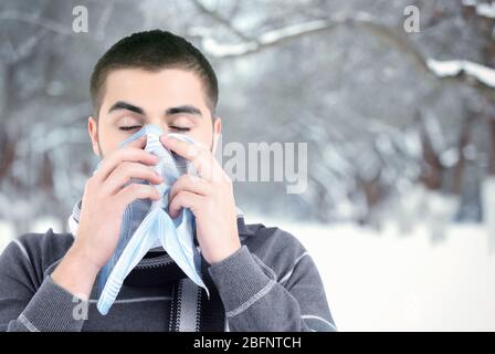 Kranker Mann mit Taschentuch im Winter, im Freien Stockfoto