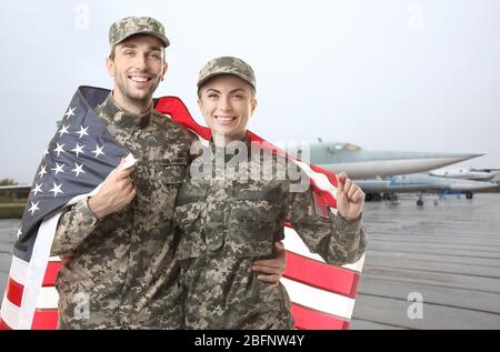 Militärpaar mit USA Flagge auf Flugplatz Stockfoto