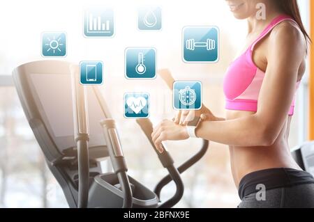 Anwendungskonzept Sport. Junge Frau mit Fitness-Tracker im Fitnessstudio Stockfoto