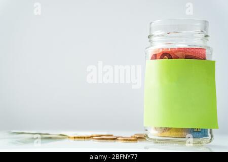 Warschau, Polen 04.02.2020. Münzen im Glas mit leerem Etikett. Nahaufnahme Stockfoto