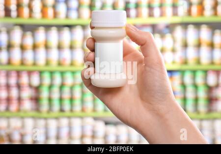 Frau mit einer Flasche Babynahrung im Laden Stockfoto