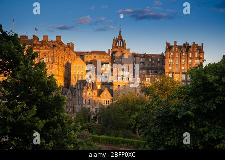 Die Altstadt von Edinburgh mit der St. Giles' Cathedral und einem aufgehenden Mond von der Princes Street aus gesehen Stockfoto