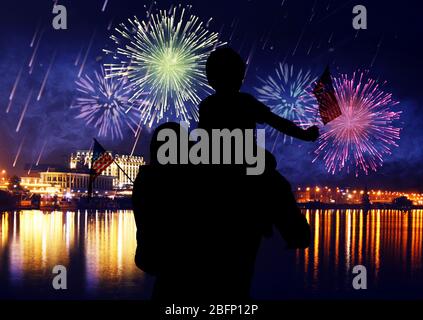 Familie mit amerikanischen Fahnen und Feuerwerk am Himmel. Weihnachtsfeier Stockfoto