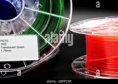 Rollen von 1,75 mm 3d-Druck-Filament, transluzent grün und transluzent orange, dunkler Hintergrund Stockfoto