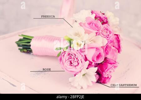 Schöner Hochzeitsstrauß mit Blumennamen auf Holzstuhl Stockfoto