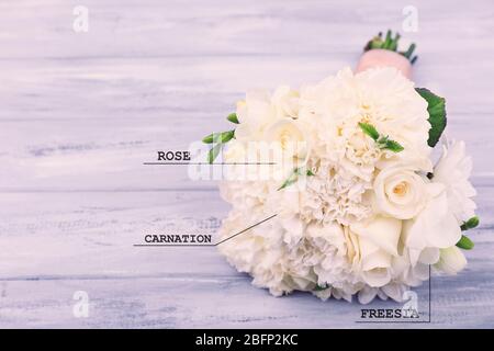 Schöner Brautstrauß mit Blumennamen auf Holzhintergrund Stockfoto