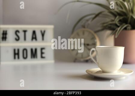 Arbeiten Sie von zu Hause während der Corona-Virus-Pandemie.Home Office-Schreibtisch. Hauspflanze, Tasse Kaffee und stationär auf weißem Hintergrund Stockfoto