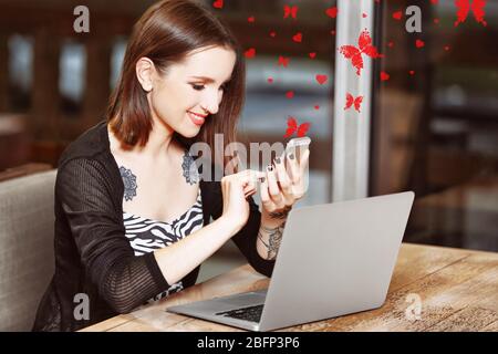 Junge Frau mit Laptop im Cafe Stockfoto