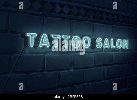 Schild Tattoo Salon auf Backstein Wand Hintergrund Stockfoto