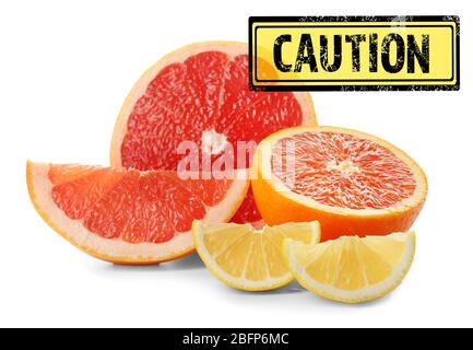 Konzept der Allergiegefahr. Verschiedene Zitrusscheiben mit Stempel Vorsicht auf weißem Hintergrund. Stockfoto